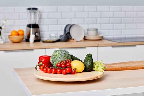 Friss zöldségek egy konyhai deszkán, letisztult kompozíció